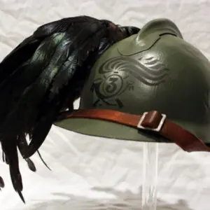 A green helmet with black feathers on top of it.