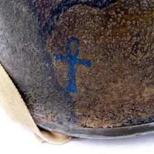 A close up of the cross on an old bell