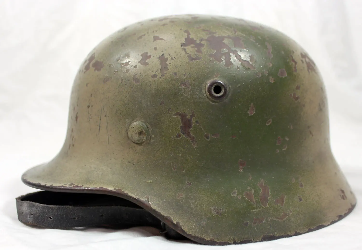 A green helmet with brown spots on it.