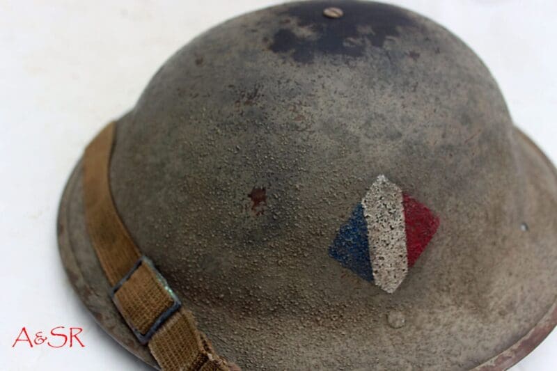 A close up of the side of an old military helmet.