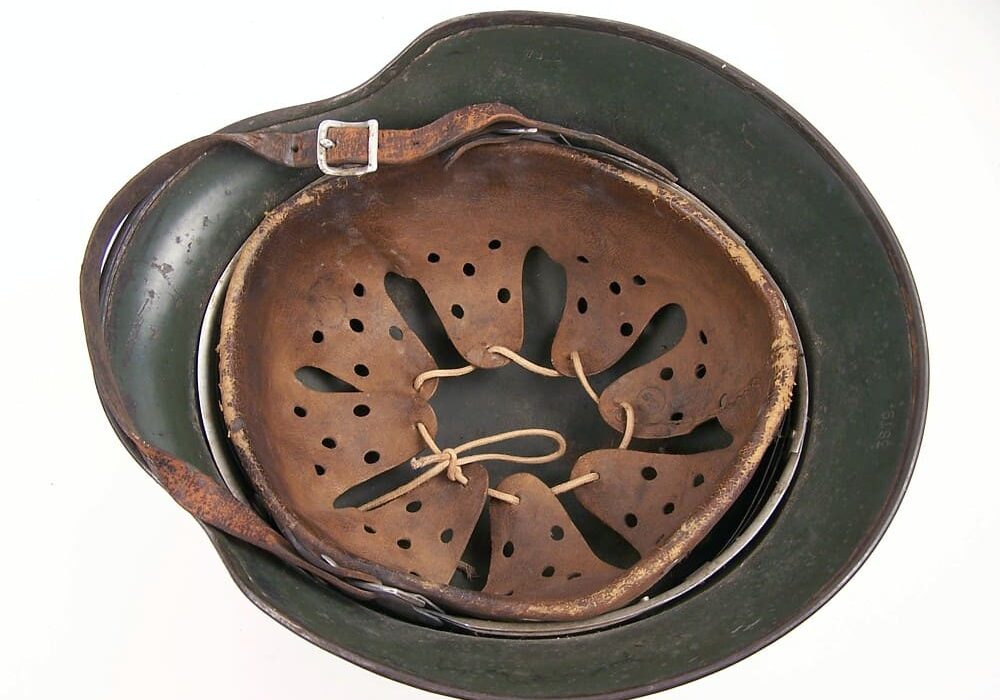 A green helmet with holes in it and a strap around the bottom of it.