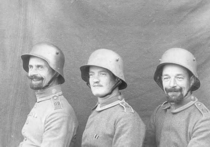 Three men in uniforms and helmets are posing for a picture.