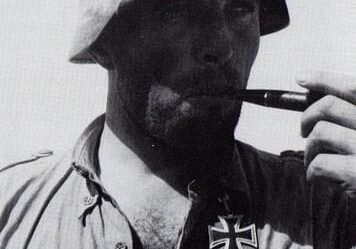 A man in german military uniform smoking a pipe.